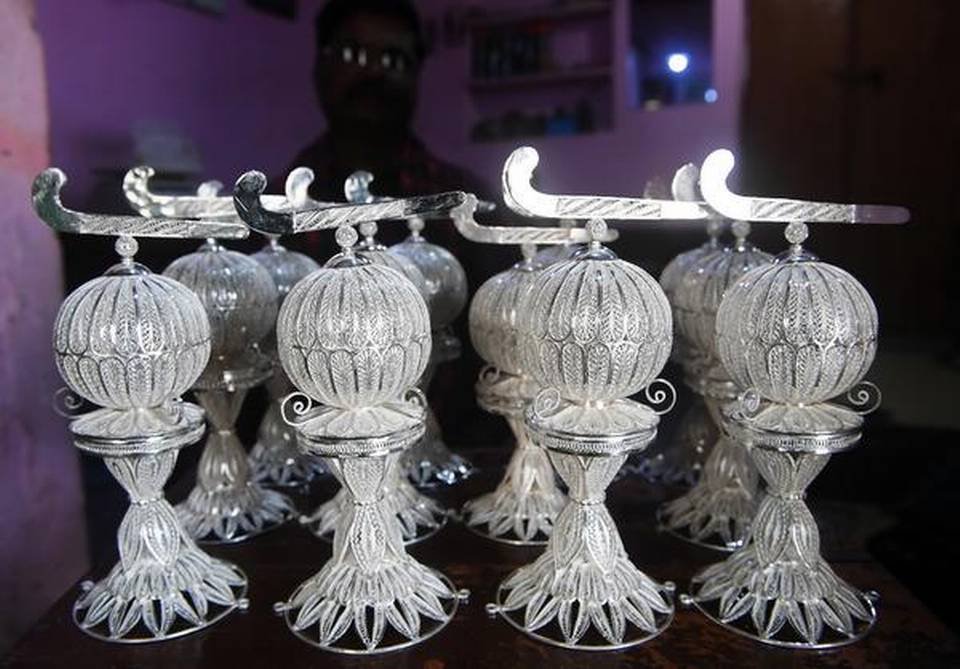 Silver filigree replicas of Hockey World Cup trophies.